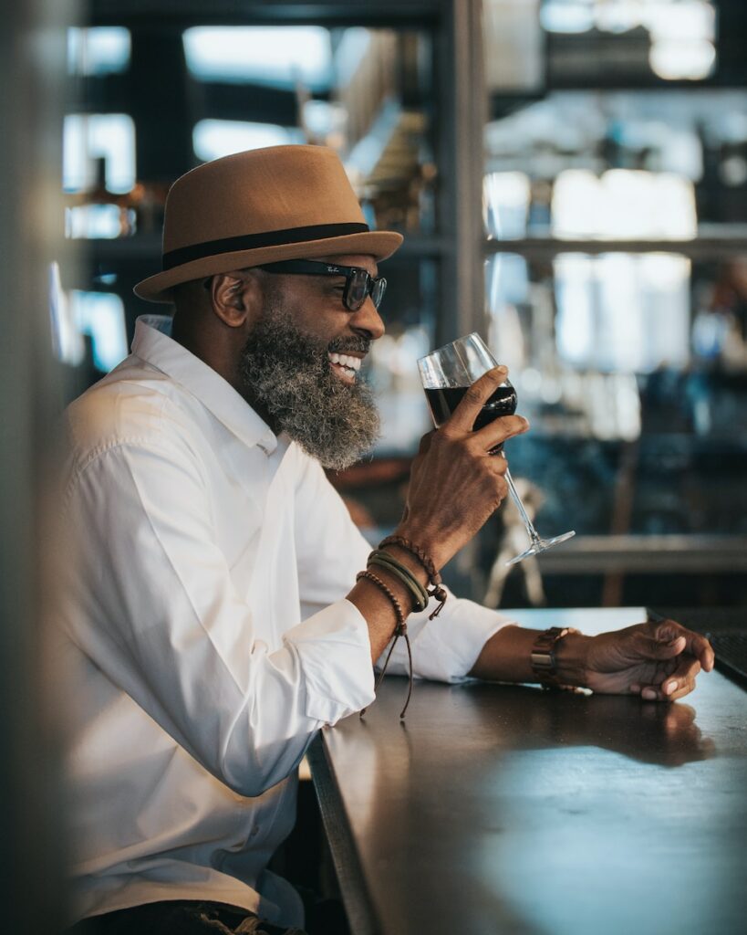 Waiter job offer: smiling man, glass of wine in hand